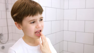 Child touching tooth